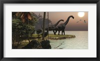 Framed Two Brachiosaurus dinosaurs enjoy a beautiful sunset