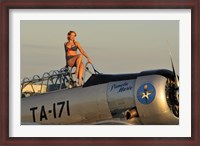 Framed 1940's style pin-up girl sitting on the cockpit of a World War II T-6 Texan