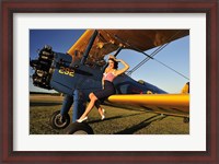 Framed 1940's style pin-up girl sitting on the wing of a Stearman biplane