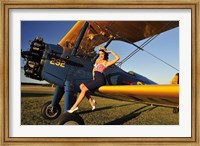 Framed 1940's style pin-up girl sitting on the wing of a Stearman biplane