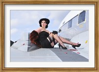 Framed Glamorous woman in 1940's style attire sitting on a vintage aircraft