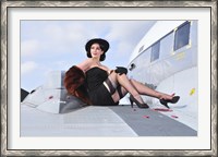 Framed Glamorous woman in 1940's style attire sitting on a vintage aircraft