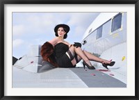 Framed Glamorous woman in 1940's style attire sitting on a vintage aircraft