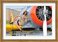 Framed 1940's style pin-up girl posing on a T-6 aircraft