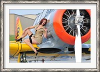 Framed 1940's style pin-up girl posing on a T-6 aircraft