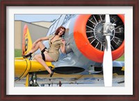 Framed 1940's style pin-up girl posing on a T-6 aircraft