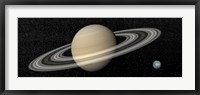 Framed Large planet Saturn and its rings next to small planet Earth