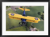 Framed Boeing Stearman Model 75 Kaydet flying over fields