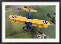 Framed Boeing Stearman Model 75 Kaydet flying over fields