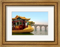 Framed Summer Palace, a traditional Dragon Boat passes the Seventeen Arch Bridge, Kunming lake, Beijing, China