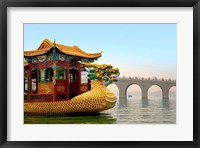 Framed Summer Palace, a traditional Dragon Boat passes the Seventeen Arch Bridge, Kunming lake, Beijing, China