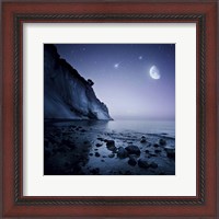 Framed Rising moon over ocean and mountains against starry sky