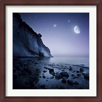 Framed Rising moon over ocean and mountains against starry sky