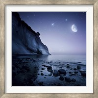 Framed Rising moon over ocean and mountains against starry sky