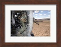 Framed HH-60G Pave Hawk gunner fires his GAU-17 machine gun
