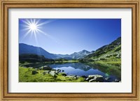 Framed Muratov Lake against blue sky and bright sun in Pirin National Park, Bulgaria