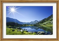 Framed Muratov Lake against blue sky and bright sun in Pirin National Park, Bulgaria