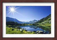Framed Muratov Lake against blue sky and bright sun in Pirin National Park, Bulgaria