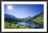 Framed Muratov Lake against blue sky and bright sun in Pirin National Park, Bulgaria