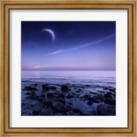 Framed Moon rising over rocky seaside against starry sky