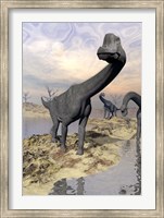 Framed Brachiosaurus dinosaurs near water with reflection by sunset and full moon