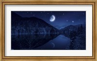 Framed Moon rising over tranquil lake in the misty mountains against starry sky
