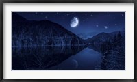 Framed Moon rising over tranquil lake in the misty mountains against starry sky