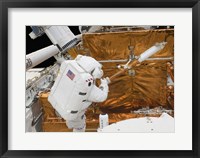 Framed Astronaut works with the Hubble Space Telescope in the cargo bay of Atlantis