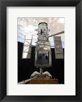 Framed Space Shuttle Atlantis' arm lifts the Hubble Space Telescope from the cargo bay