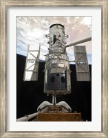 Framed Space Shuttle Atlantis' arm lifts the Hubble Space Telescope from the cargo bay