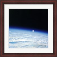 Framed Outer space shot of storm system in early stage of formation with moon in background