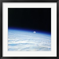 Framed Outer space shot of storm system in early stage of formation with moon in background