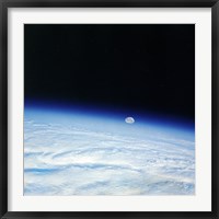 Framed Outer space shot of storm system in early stage of formation with moon in background