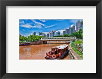 Framed Singapore skyline and tug boats on river.