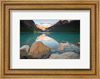 Framed Rocky Mountains and boulders reflected in Lake Louise, Banff National Park, Alberta, Canada