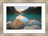 Framed Rocky Mountains and boulders reflected in Lake Louise, Banff National Park, Alberta, Canada