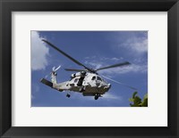 Framed Crew Chief looks out the side door of a helicopter in flight