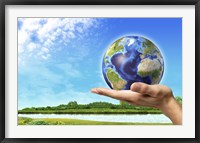 Framed Human Hand Holding Earth Globe with a Green Landscape Background