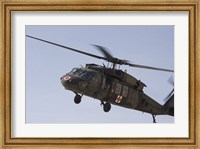 Framed UH-60 Blackhawk Medivac helicopter flies over Camp Warhorse
