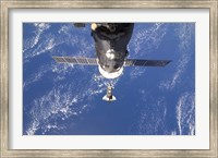 Framed Space Shuttle Discovery approaches the International Space Station