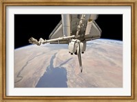 Framed Aft Section of the Docked Space Shuttle Discovery and the Station's Robotic Canadarm2