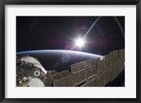 Framed International Space Station Backdropped by the Bright Sun over Earth's Horizon