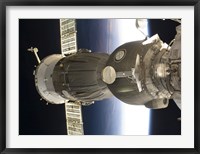 Framed Soyuz spacecraft backdropped by Earth