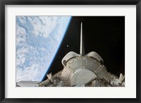 Framed Space Shuttle Discovery's Payload Bay Backdropped by Earth's Horizon