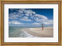 Framed Woman walking on white sand beach of Beachcomber Island, Mamanucas Islands, Fiji