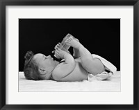 Framed 1950s Baby Lying On Back Drinking From Bottle
