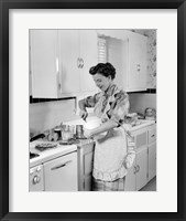 Framed 1950s Housewife In Kitchen Mixing Ingredients